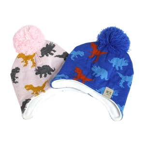Detail of dinosaur knit hats for kids with plush fleece lining and faux fur pom-poms