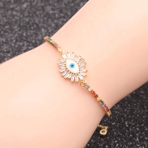 Detail of gold evil eye bracelet with colorful zircons on a model's wrist