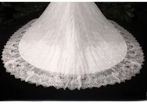 Gros plan sur la traîne de robe mariée en tulle multicouche avec dentelle et sequins