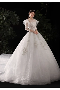 Détail d'une robe de mariée en dentelle blanche avec broderies et traîne à paillettes