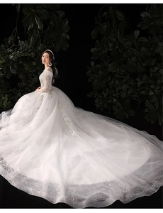 Détails de robe de mariée en dentelle blanche avec manches longues et traîne scintillante