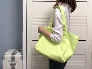 Detailweergave van de grote neongroene canvas tas die textuur en capaciteit laat zien