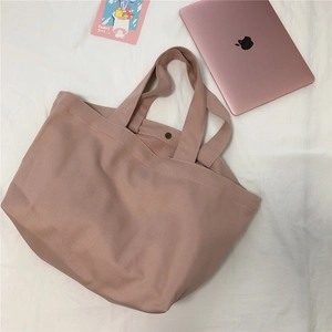 Detailopname van roze canvas tas met twill textuur en metalen magnetische sluiting