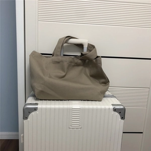 Detail van khaki canvas draagtas op koffer met dikke hengsels en grote opbergcapaciteit