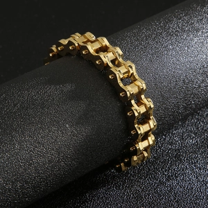 Macro shot of industrial golden bicycle chain bracelet on dark leather surface
