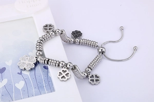 Detailed view of silver clover bracelet with zircon charms and adjustable chain