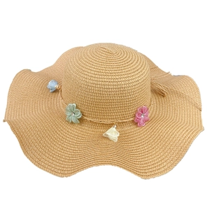 Women's straw sun hat with colorful floral garland and wide wavy brim for beach vacations