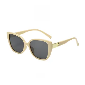 Detail of fashion square sunglasses featuring beige frame and golden V-shaped metal hinge