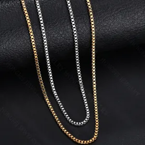 Sleek box chain necklaces in gold and silver steel finishes on a leather texture