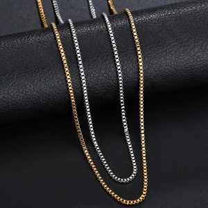 Detail of gold and silver box chains on a textured leather display roll