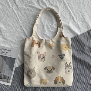 Detailed view of beige canvas tote with cartoon dog prints and lavender lining details