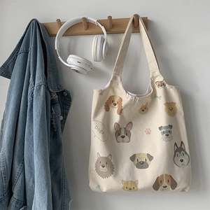 Detail of canvas tote bag featuring hand-drawn dog illustrations on white fabric