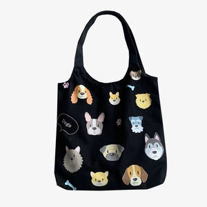 Black canvas tote bag with various cartoon dog breed prints and long shoulder straps
