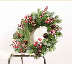 Macro shot of 50cm Christmas wreath with snowy red berries and eucalyptus on a chair