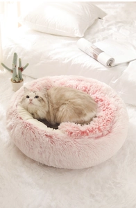 Vista dettagliata di una cuccia per gatti in morbido peluche rosa con forma rotonda
