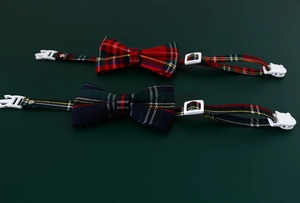 Close-up of adjustable pet collars with red and green plaid patterns and buckles