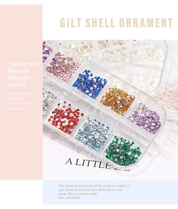 Close-up of assorted colorful nail art rhinestones and pearls in a clear grid storage box
