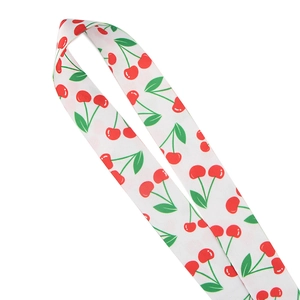 Close-up of fabric lanyard featuring red cherry and green leaf pattern on white background