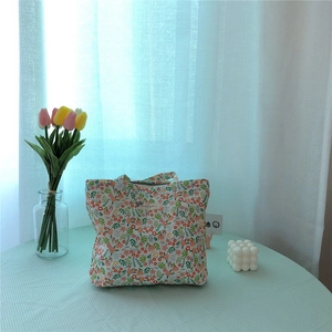 Close-up of floral cotton tote bag with vintage flower patterns on a checkered tablecloth
