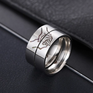 Polished titanium steel couple rings with hand-holding line art on black background
