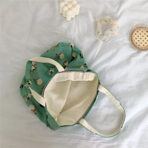Detail view of cotton floral tote bag with zipper closure and smooth beige lining