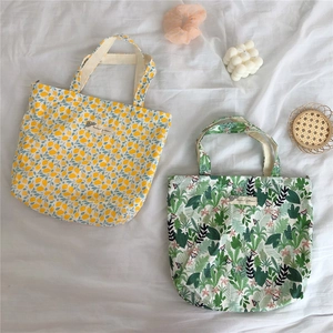 Detail of floral cotton tote bags featuring yellow lemon and green tropical leaf patterns