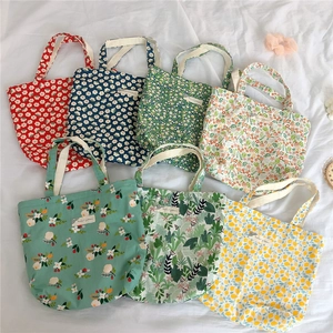 Flat lay of multiple floral cotton canvas tote bags with various botanical prints