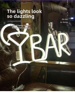 Close-up of a cocktail glass LED neon sign with BAR lettering on a vintage chair