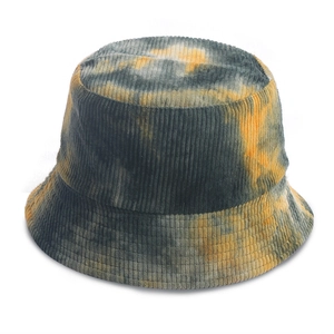 Detailed texture of tie-dye corduroy fabric on a bucket hat in orange and grey-green