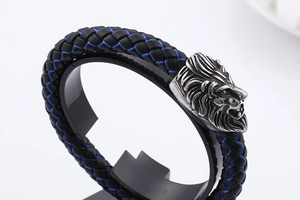 Detail of lion head bracelet featuring black braided leather and blue stitching