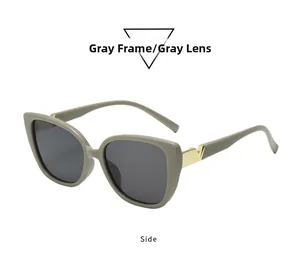 Detail of square oversized gray sunglasses featuring elegant golden metal V accents