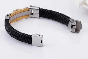 Detailed view of black braided leather bracelet with silver and gold stainless steel clasp