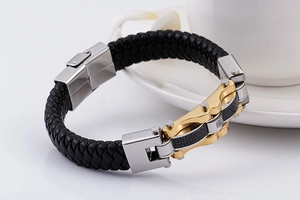 Detail of black braided leather men's bracelet with gold silver steel and carbon fiber