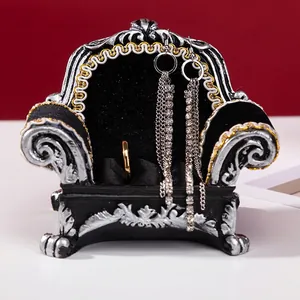 Vintage sofa-shaped jewelry display stand with retro silver relief and gold edges