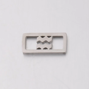 Macro view of silver stainless steel rectangular buckle with grooved wavy slot design