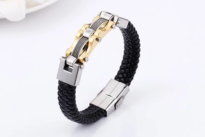 Detail of woven leather bracelet with gold accents and steel wire rope elements