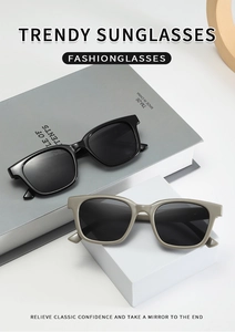 Detail of square oversized sunglasses in black and taupe on minimalist display