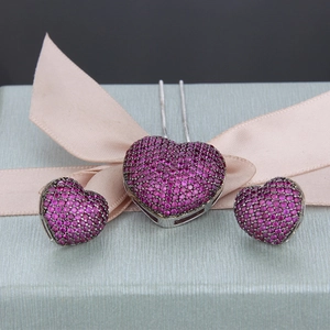 Detail of pink zircon heart necklace and earrings set on a textured gift box