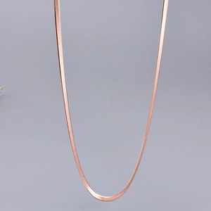 Macro view of rose gold snake bone chain showing its flat interwoven links and polished texture