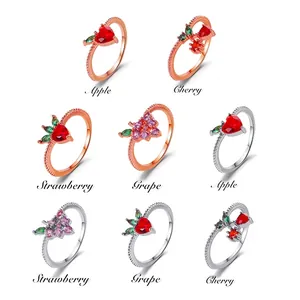 Cute fruit themed rings set with apple cherry strawberry and grape designs on white background
