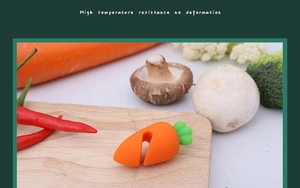 Silicone carrot pot lid lifter on a wooden board showing heat-resistant material