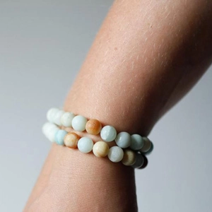 Detail of natural sunstone and amazonite beaded bracelets worn on a wrist