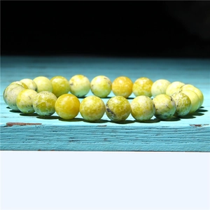 Detailed macro view of natural sunstone beaded bracelet with yellow-green mineral textures