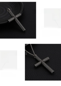 Detail of cross pendant featuring industrial black knurled texture and stainless steel chain