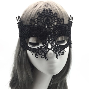 Close-up of elegant black lace masquerade mask showing intricate vintage patterns on model