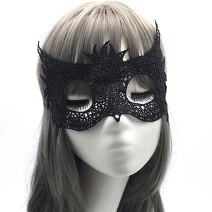 Close-up of black lace masquerade mask with intricate floral patterns on model