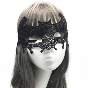 Close-up of black lace bat mask showing intricate patterns on woman for masquerade