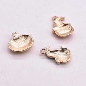 Detailed close-up of gold enamel pumpkin and wizard hat alloy charms for DIY jewelry making