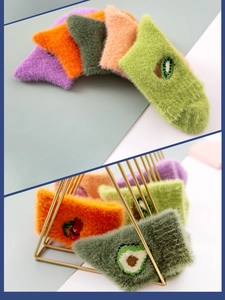 Detail of plush avocado fleece socks with warm mink velvet texture and fruit embroidery