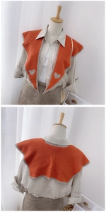 Front and back detail of an orange knitted shoulder shawl with grey heart pattern